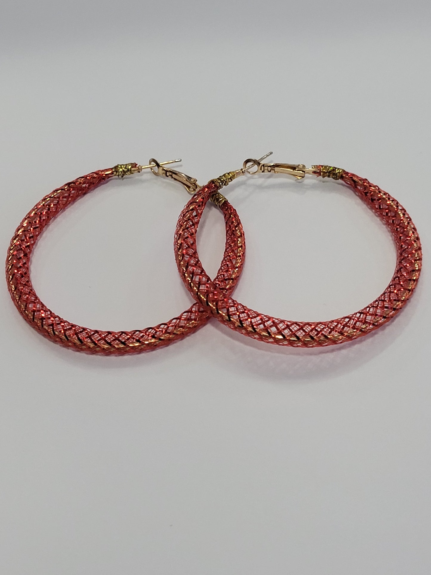Red lace hoop earrings on a white surface