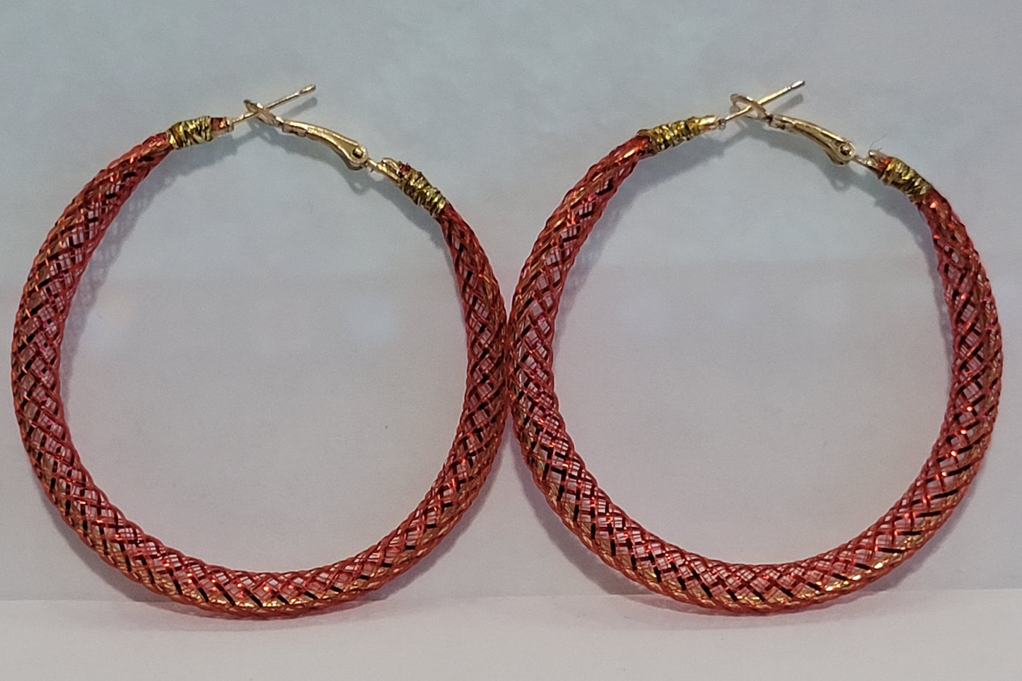 Red lace hoop earrings on a white background