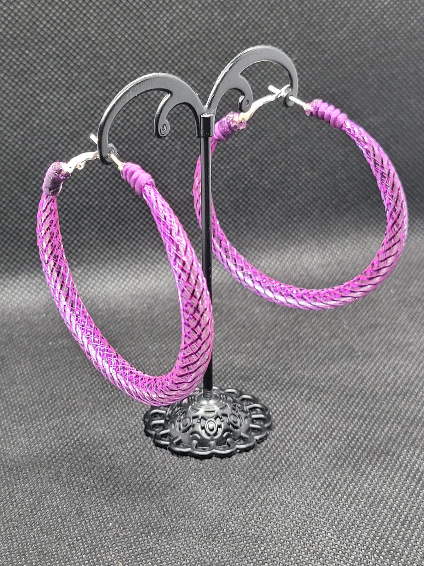 Purple braided lace on a display on a gray background