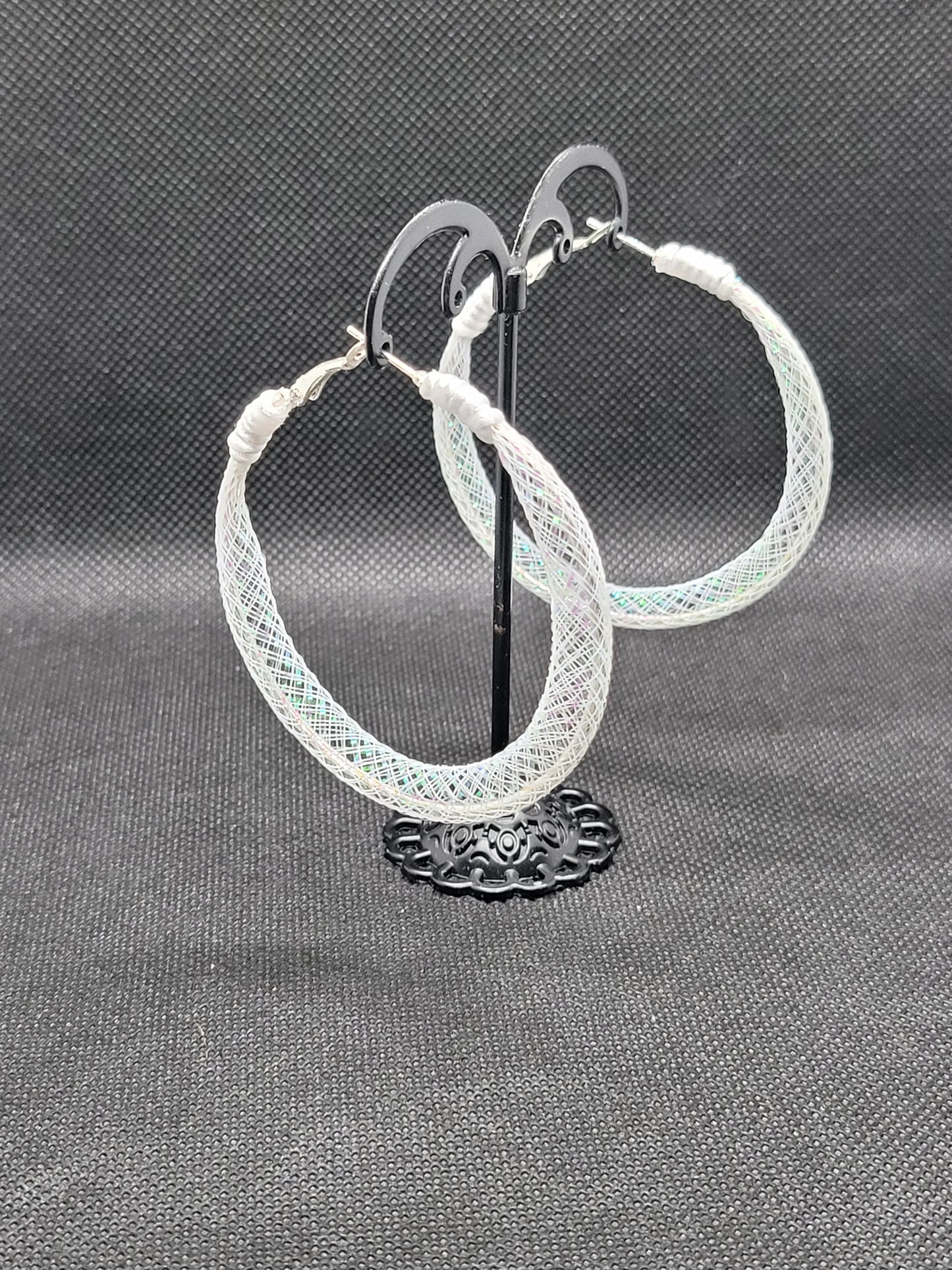 White lace and Silver hoop earrings on a gray background