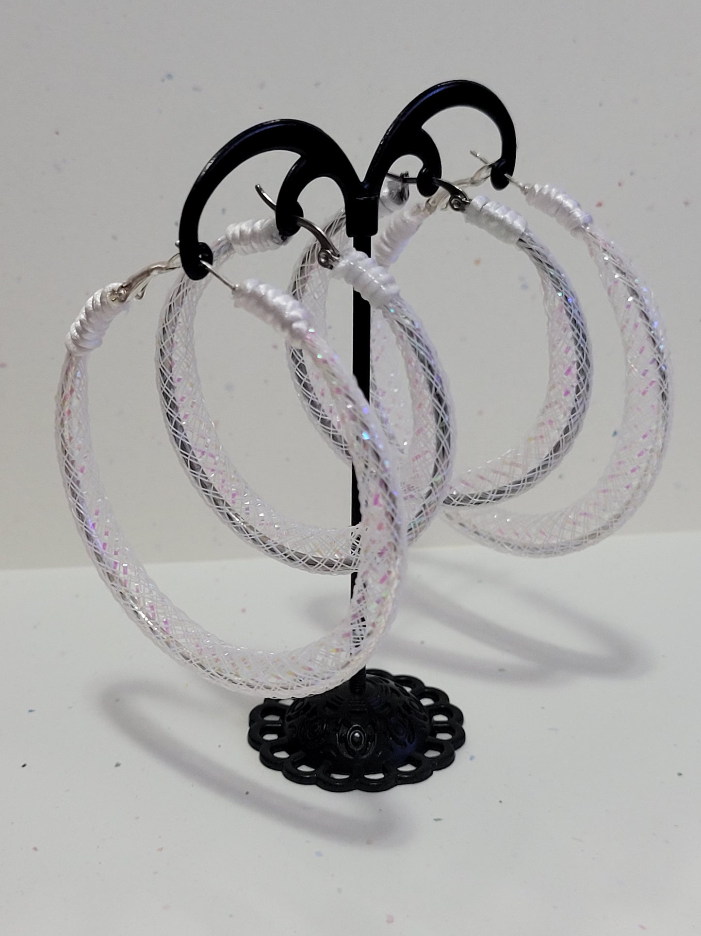 White lace and silver earring on black display