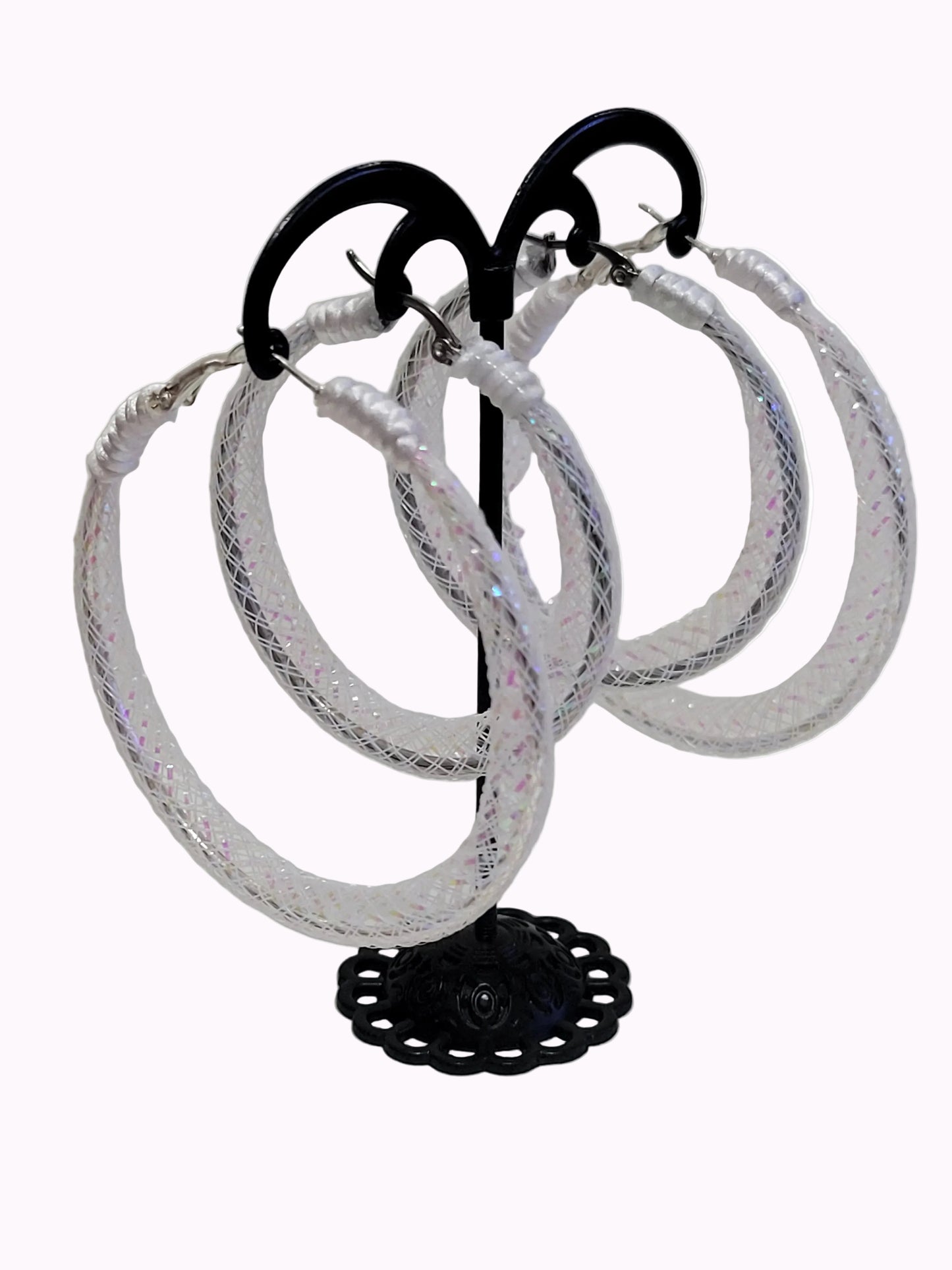 White lace and silver earring on black display