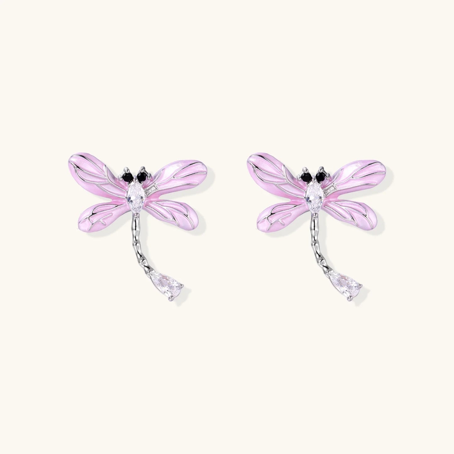 Long drop earrings with translucent lavender enamel dragonfly wings and white gold plated segmented bodies on white background