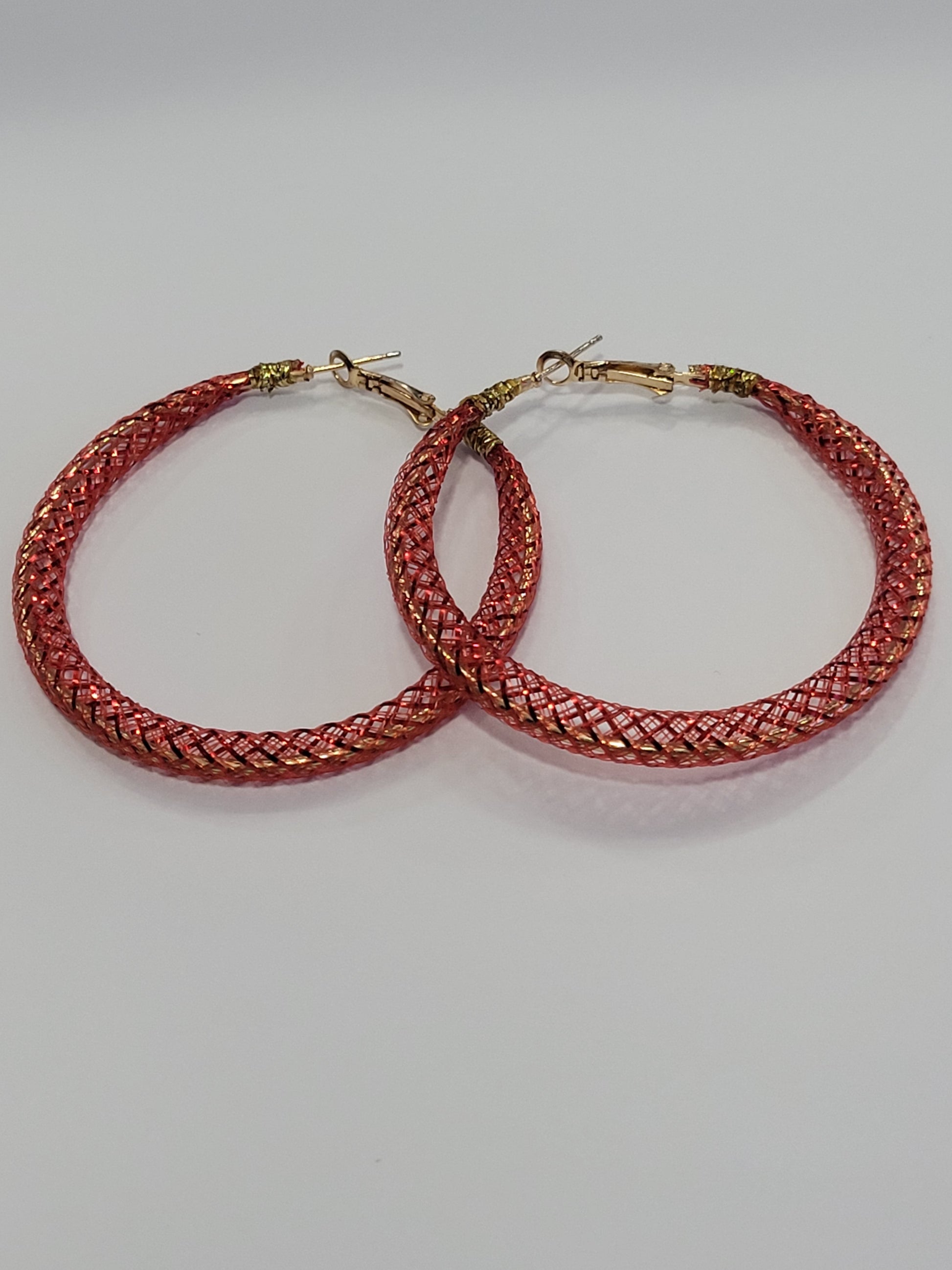 Red lace hoop earrings on a white surface