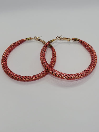 Red lace hoop earrings on a white surface