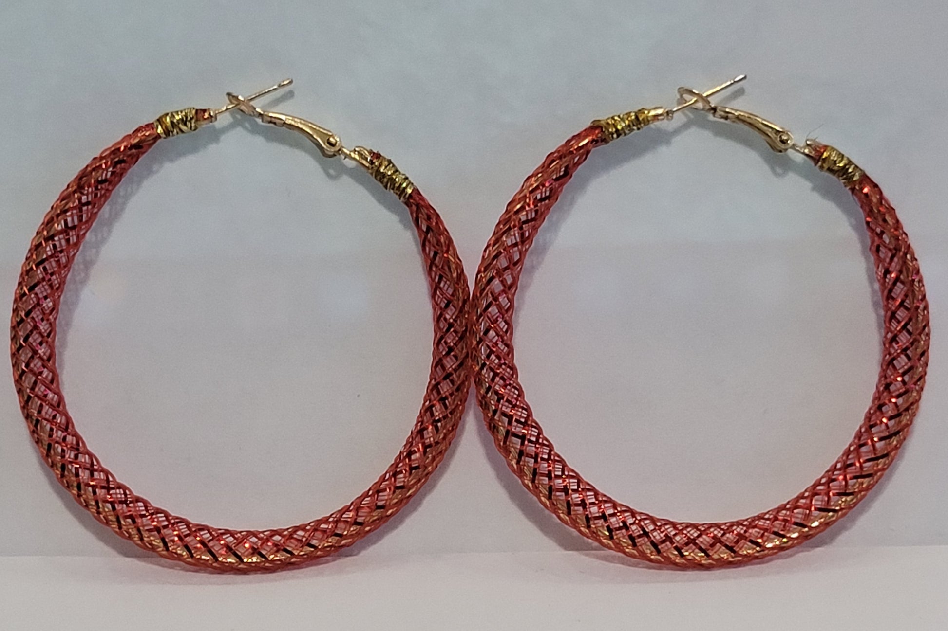 Red lace hoop earrings on a white background