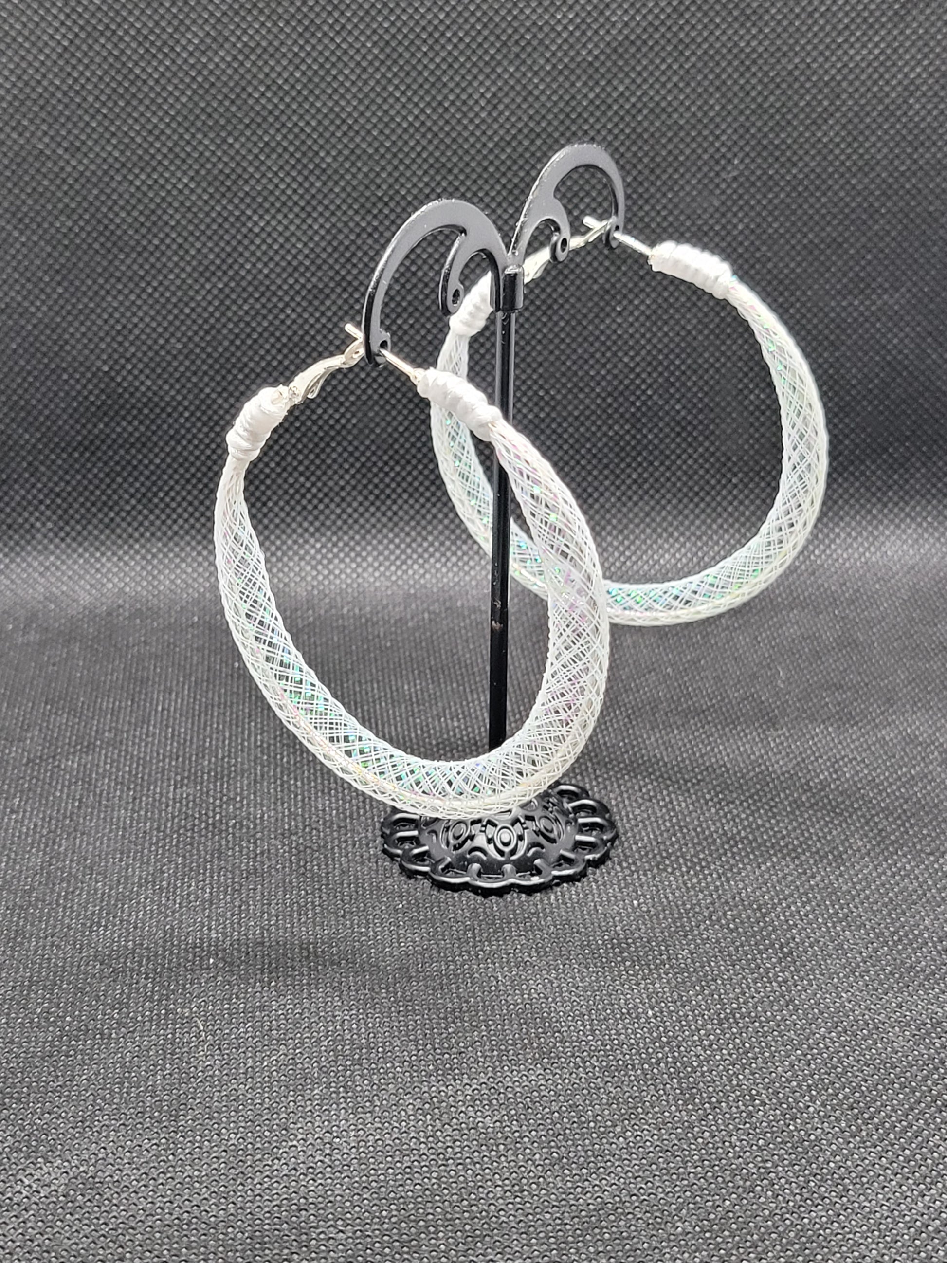 White lace and Silver hoop earrings on a gray background