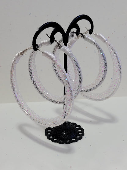 White lace and silver earring on black display